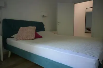a bed with a green headboard and a pillow on it at Ellie Star Apartment in Belgrade