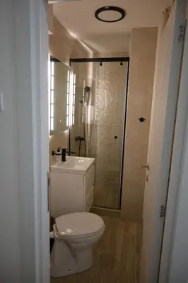 a white bathroom with a toilet and a shower at Ellie Star Apartment in Belgrade