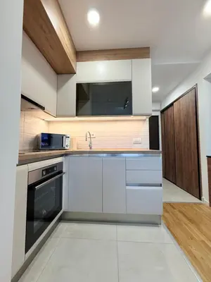 a kitchen with white cabinets and a sink at Apartment UNA in Pančevo