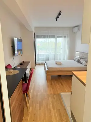 a small room with a bed and a desk and a desk at Apartment UNA in Pančevo