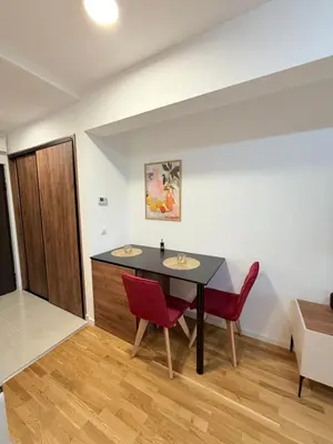a dining room with a table and two red chairs at Apartment UNA in Pančevo