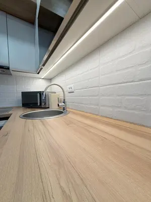 a kitchen with a sink and a wooden floor at Apartment UNA in Pančevo