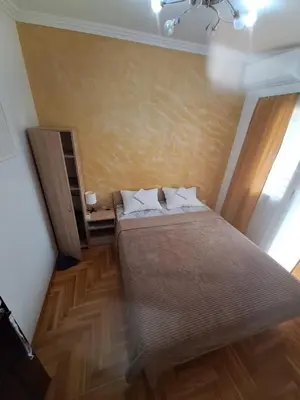 a small bedroom with a bed and a window at Rooms1 in Beograd