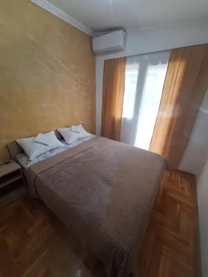 a bedroom with a large bed with a window at Rooms1 in Beograd