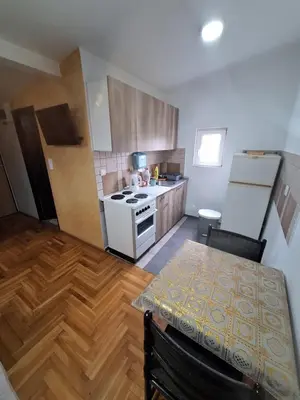 a kitchen with a table and a white stove top oven at Rooms1 in Beograd