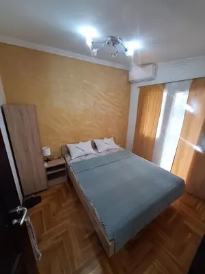 a bedroom with a bed in a room with a window at Rooms1 in Beograd