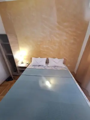 a bed with two pillows on it in a room at Rooms1 in Beograd