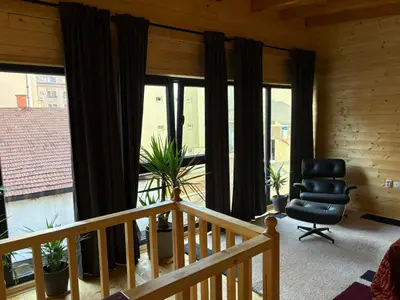 a room with a balcony with a chair and windows at Beli Bor in Vračar (historical)