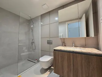 a bathroom with a toilet and a glass shower at BW Quartet 302 deluxe apartments in Belgrade