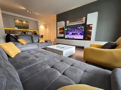 a living room with a couch and a flat screen tv at BW Quartet 302 deluxe apartments in Belgrade