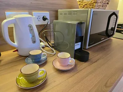 a counter with cups and a coffee maker and a microwave at BW Quartet 302 deluxe apartments in Belgrade