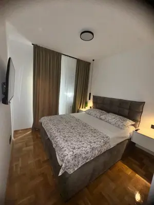a bedroom with a large bed and a window at Fairy tale apartment 9 in Voždovac