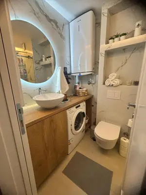 a bathroom with a sink and a washing machine at Fairy tale apartment 9 in Voždovac