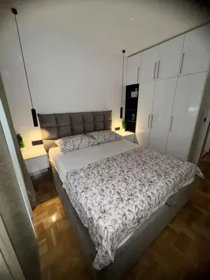 a bedroom with a large bed and white cabinets at Fairy tale apartment 9 in Voždovac