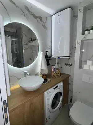 a bathroom with a sink and a washing machine at Fairy tale apartment 9 in Voždovac