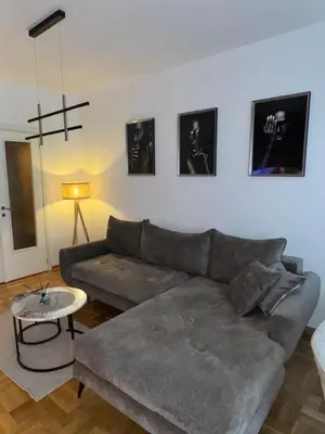 a living room with a gray couch and a table at Fairy tale apartment 9 in Voždovac