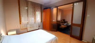 a bedroom with a bed and a chair and a window at Apartman Savka in Belgrade
