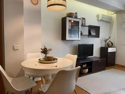 a living room with a table and chairs and a tv at Belgrade Blue Oasis in Belgrade