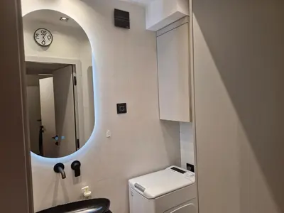 a bathroom with a white toilet and a mirror at Urban Central Stay Belgrade in Belgrade