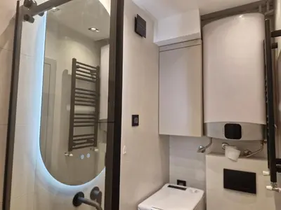 a bathroom with a toilet and a sink and a mirror at Urban Central Stay Belgrade in Belgrade