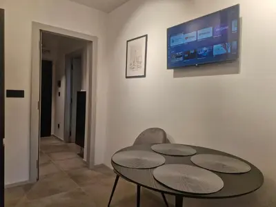 a table and a chair and a tv on a wall at Urban Central Stay Belgrade in Belgrade
