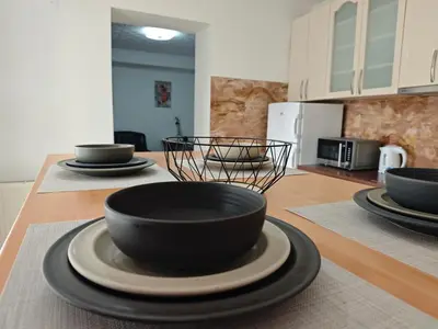 a kitchen with black bowls and plates on a table at NeNa Apartmani - Ruma in Ruma