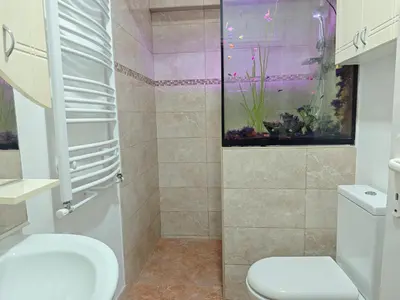a bathroom with a toilet and a fish tank at NeNa Apartmani - Ruma in Ruma