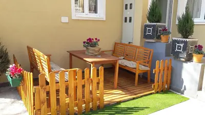 a deck with a table and chairs and a cat sitting on it at Bed&Breakfast kod Smilje in Belgrade