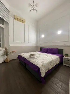 a bedroom with a purple bed and a window at Skadarlija Residence in Belgrade