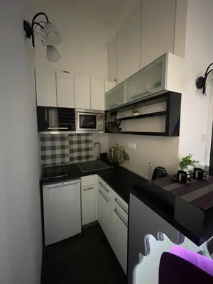 a kitchen with white cabinets and black counter tops at Skadarlija Residence in Belgrade