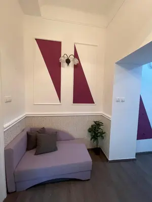 a living room with a purple couch and a large letter k at Skadarlija Residence in Belgrade