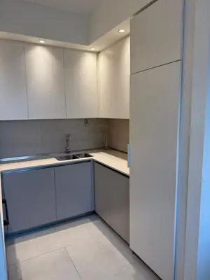 an empty kitchen with white cabinets and a sink at Belgrade Waterfront Sky & River View Residences in Belgrade