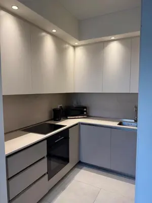 an empty kitchen with white cabinets and a sink at Belgrade Waterfront Sky & River View Residences in Belgrade