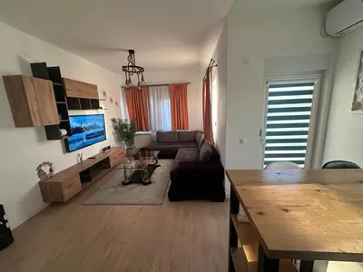a living room with a couch and a tv at Apartman 601 in Surčin