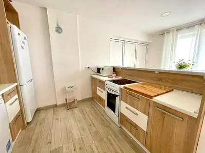a kitchen with white appliances and wooden floors at Cozy apartments in Belgrade, Čukarica, Železnik, free parking and WiFi in Belgrade