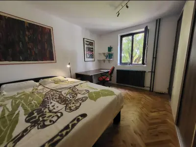 a bedroom with a bed and a desk and a window at Udobni smestaj in Belgrade