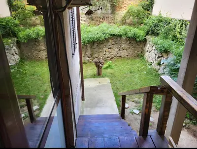 an open door to a yard with a stone wall at Udobni smestaj in Belgrade