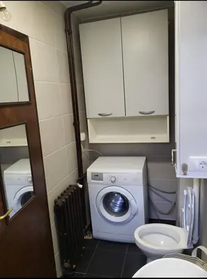 a bathroom with a washing machine and a toilet at Udobni smestaj in Belgrade