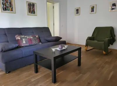 a living room with a couch and a table and a chair at Udobni smestaj in Belgrade