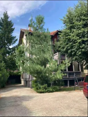 a large house with a tree in front of it at Udobni smestaj in Belgrade
