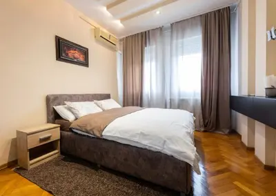 a bedroom with a bed and a window at Arena public FREE parking in front of building in Belgrade