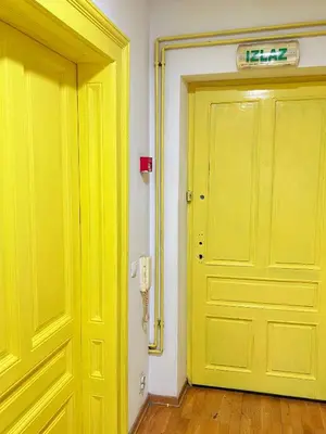 a yellow door in a room next to another door at Oneone eleven hostel in Belgrade