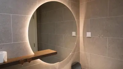 a bathroom with a shower with a round mirror at Belgrade Waterfront - Free Parking - Echo in Belgrade