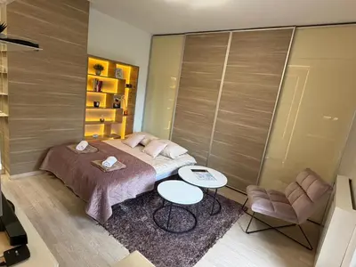 a bedroom with a bed and two tables and chairs at Urban Studio Vračar Centar - Central Belgrade in Belgrade