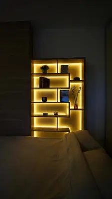 a bedroom with a bed and a shelf with lights at Urban Studio Vračar Centar - Central Belgrade in Belgrade