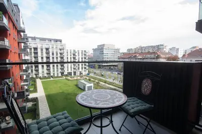 a balcony with a table and chairs and a view at Jana BW apartman in Belgrade