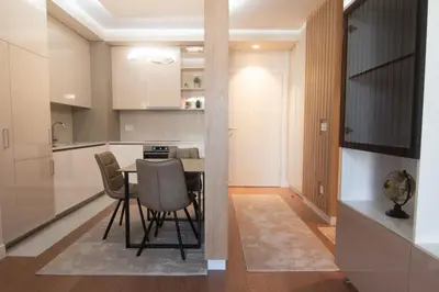 a kitchen and dining room with a table and chairs at Jana BW apartman in Belgrade