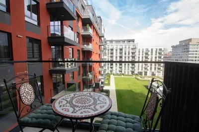 a balcony with a table and chairs and some buildings at Jana BW apartman in Belgrade