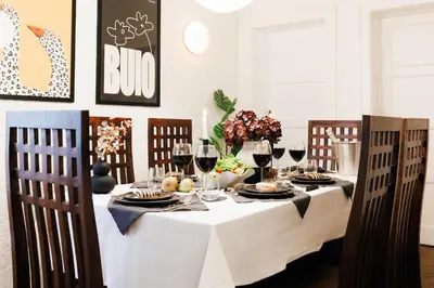 a dining room table with a white table cloth and wine glasses at Fireplace Magic 108m2 with Balcony & Foosball in Belgrade