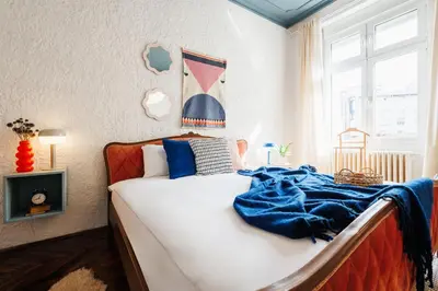 a bedroom with a bed with a blue blanket on it at Fireplace Magic 108m2 with Balcony & Foosball in Belgrade